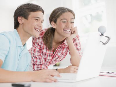 Teenagers using a computer web cam