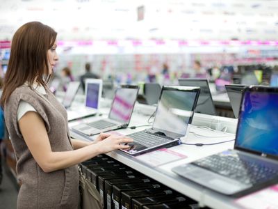 Woman browsing laptops at store