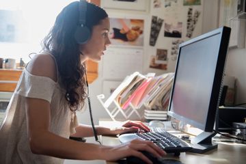 Woman wearing headphones using her desktop computer