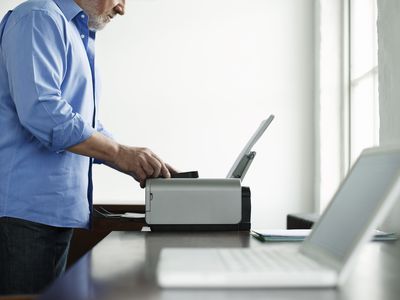 Man using a wireless printer with a laptop in the foreground