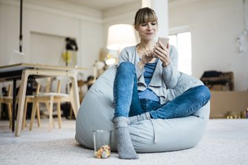 Woman using cell phone in house