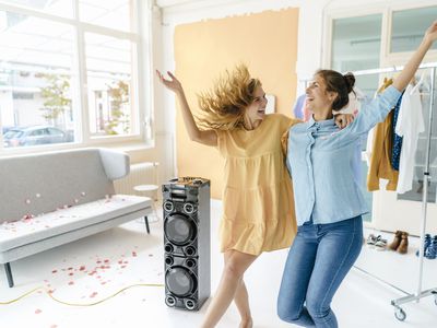 Two people dancing to music from a speaker.