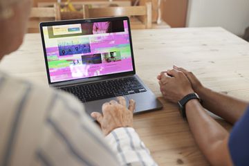 A computer laptop with vertical and horizontal lines and static on its monitor screen.