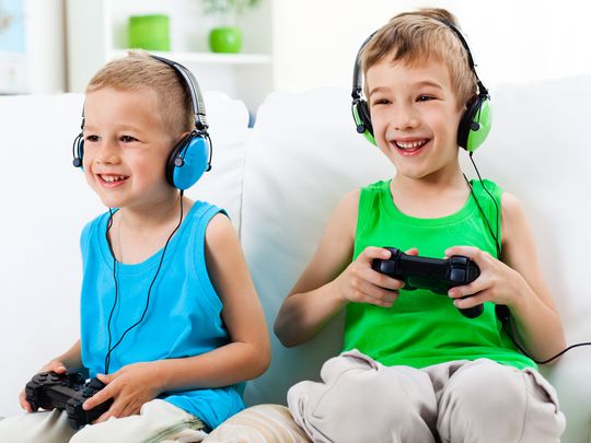 Two boys playing fun online video games on their PlayStation 4.