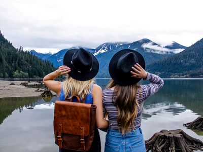 A pair of friends looking at a lake and mountains.